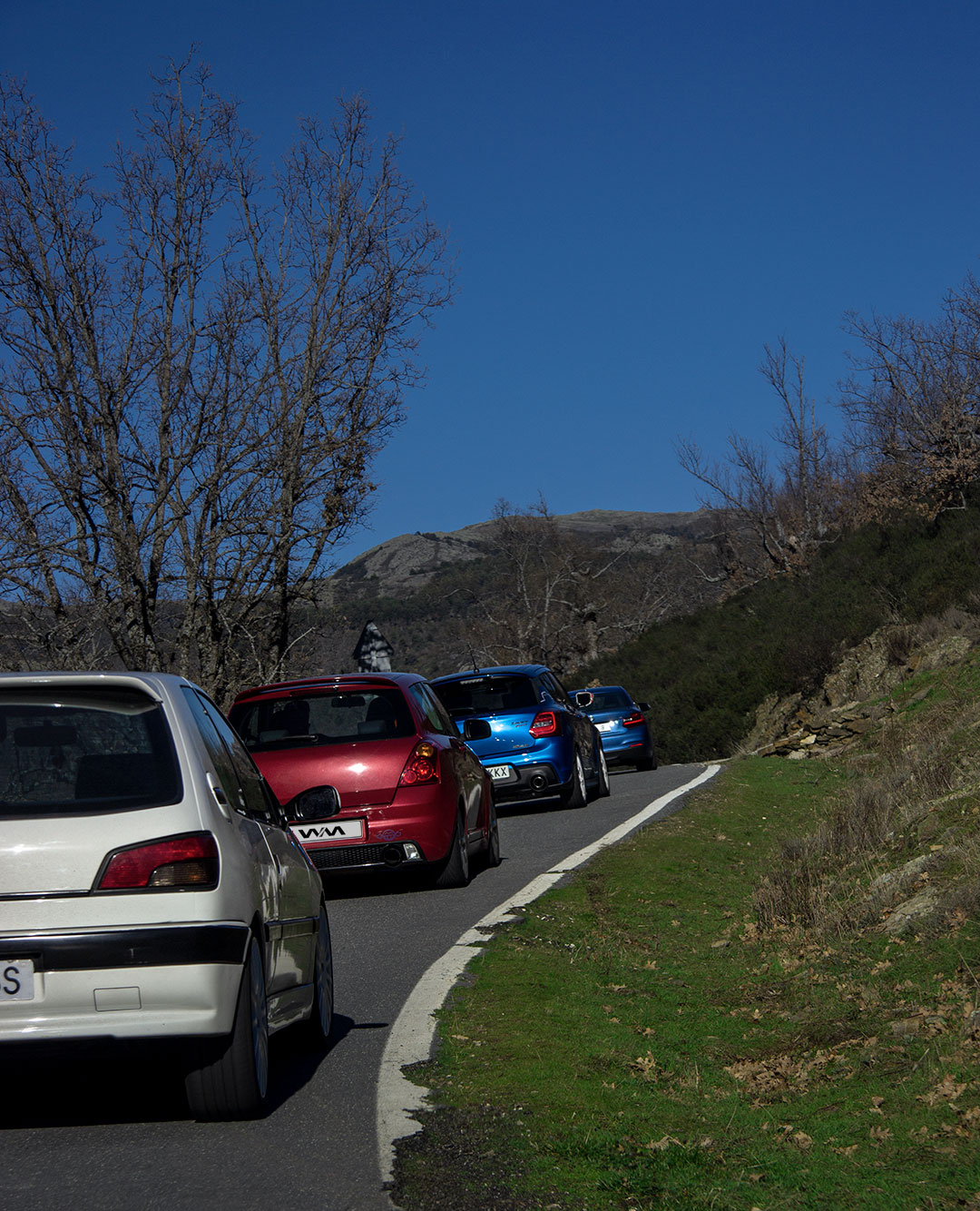 Peugeot 306 xsi, suzuki swift, suzuki swift sport y bmw 228i de camino al Puerto de la puebla durante la ruta en coche desde Madrid. Fotografía realizada desde un Renault 19 sport